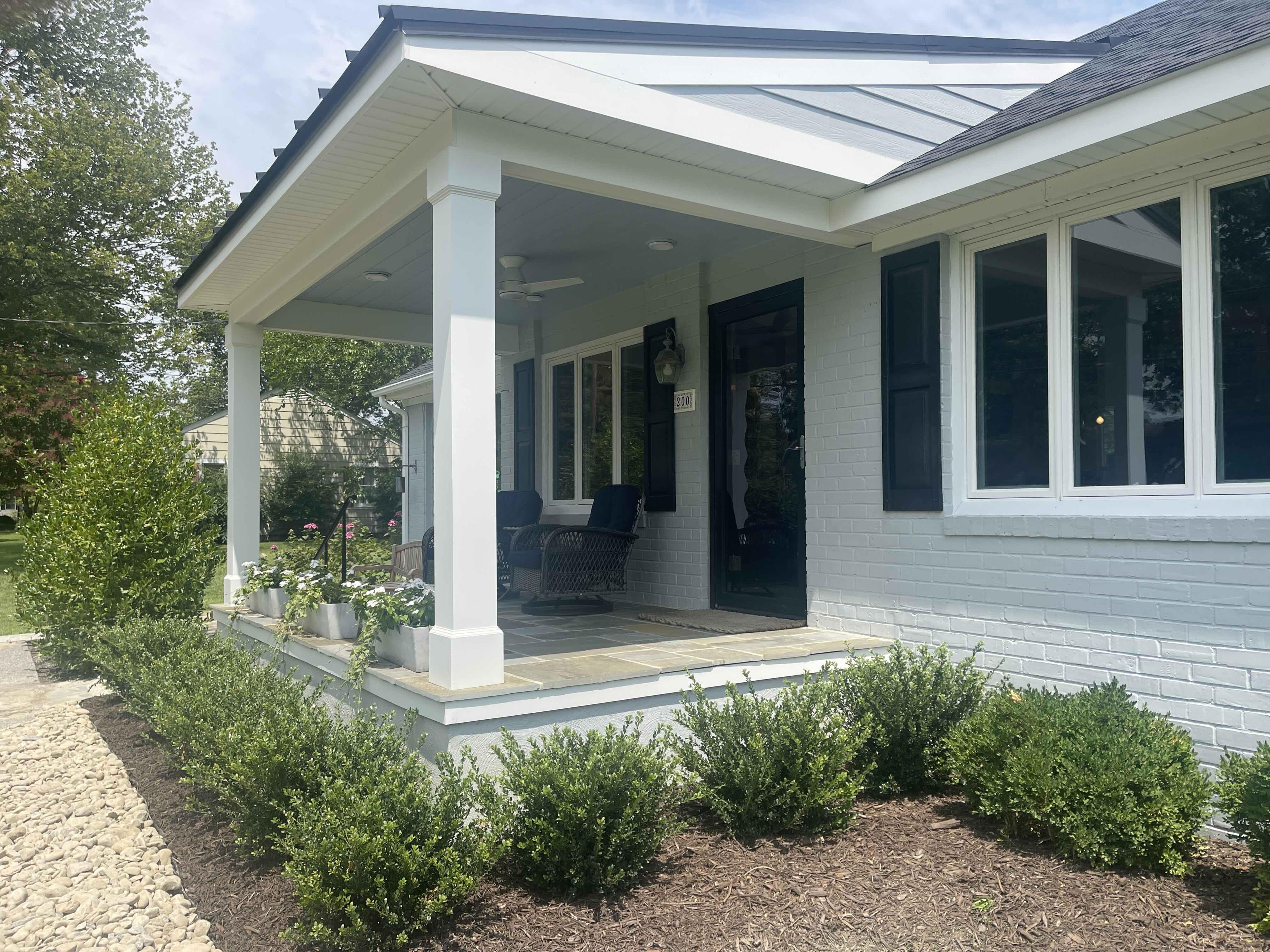 White porch columns, bluestone floor, and the front door