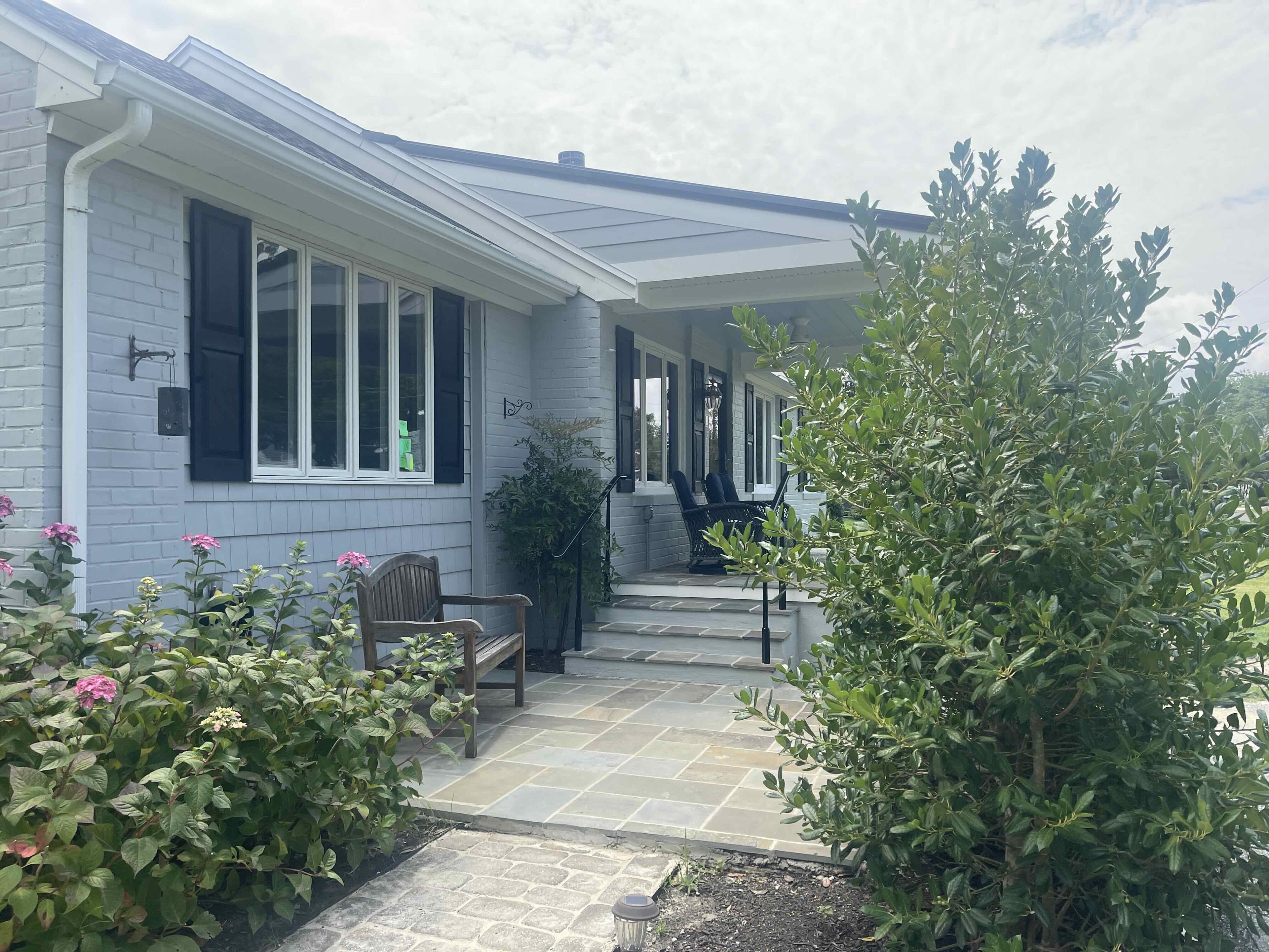 Bluestone walk leading through planted beds to the covered front porch